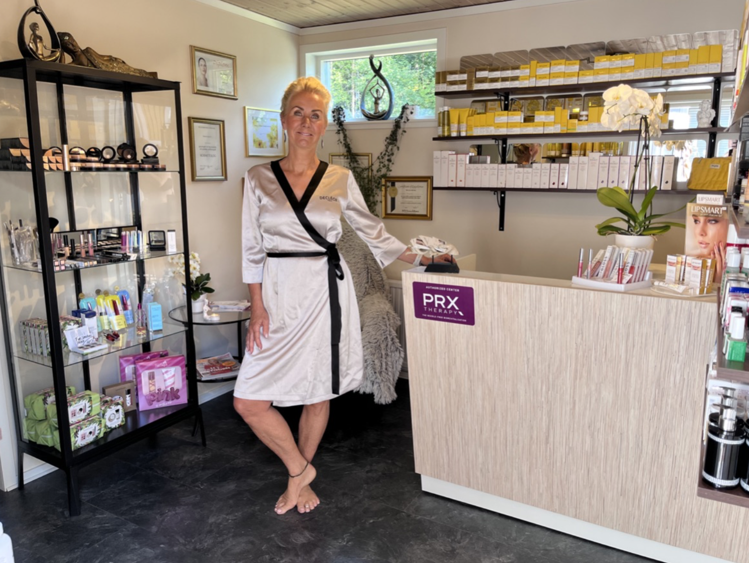Camilla i Lilla hud&spasalongens butiksdel med hudvårdsprodukter och PRX Therapy-disk