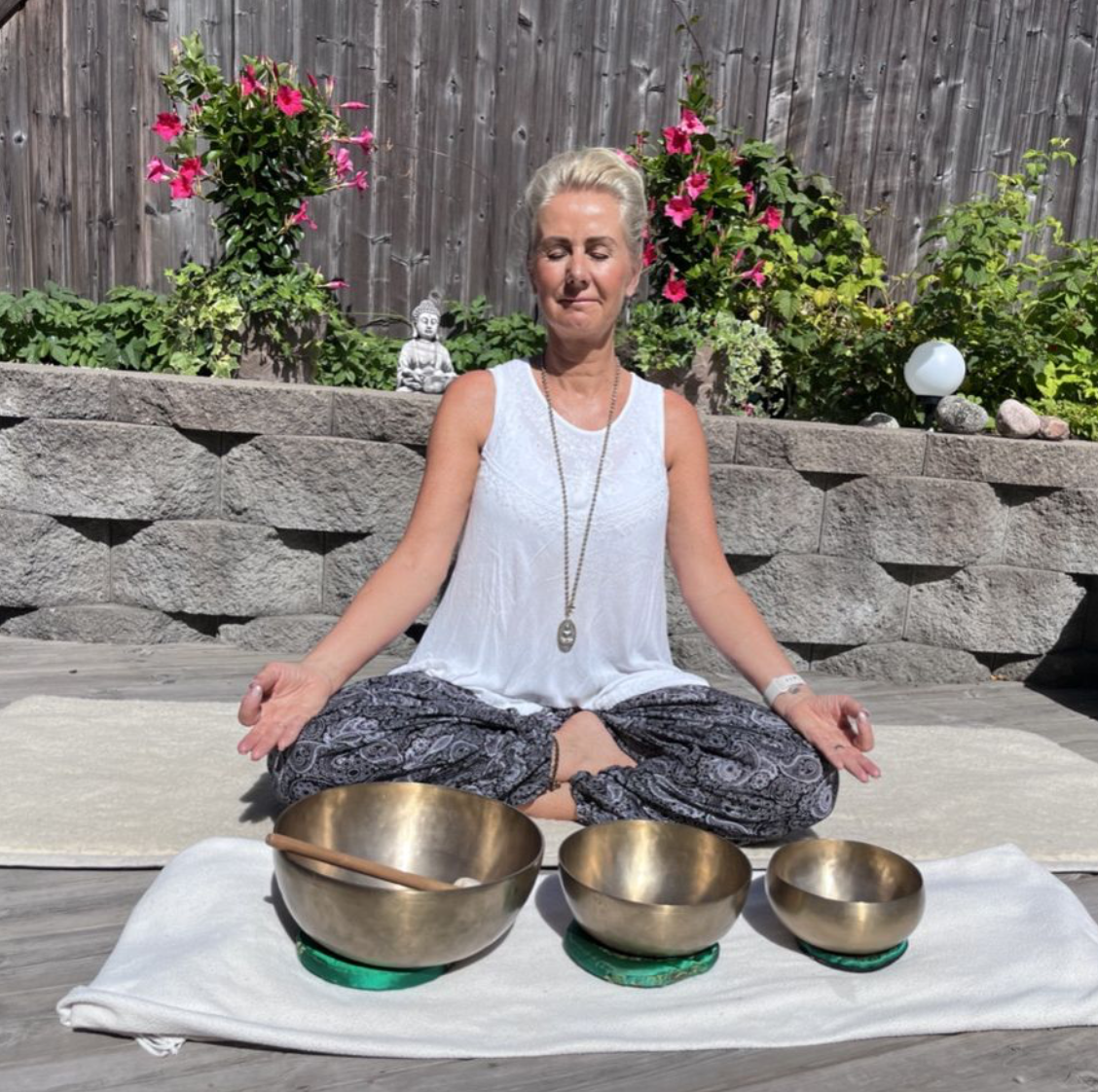Camilla mediterar med klangskålar utomhus